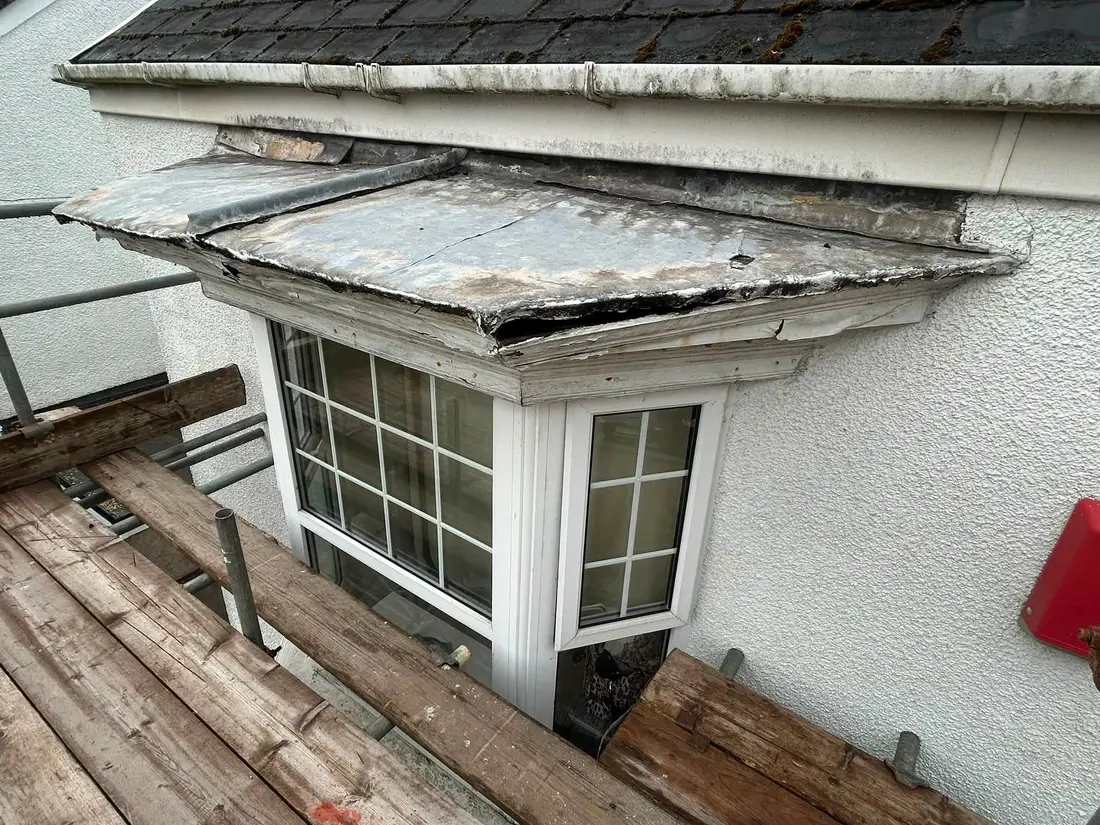 Before: Split, patched leadwork on a bay window roof re-covered