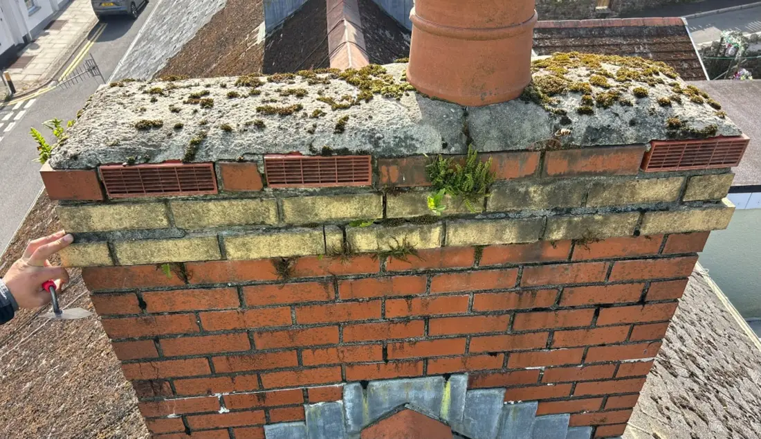 Before: Moss and growth cleared from a chimney stack, with new flaunching